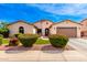 Charming single-story home featuring a well-manicured lawn and beautiful desert landscaping at 2553 E Carob Dr, Gilbert, AZ 85298