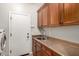 Laundry room showcasing wooden cabinetry and sink at 2553 E Carob Dr, Gilbert, AZ 85298