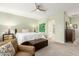 Inviting main bedroom with carpeted floors, ceiling fan, and a view into the ensuite bathroom at 2553 E Carob Dr, Gilbert, AZ 85298