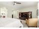 Serene main bedroom showcasing a ceiling fan, plantation shutters, and a comfortable sitting area at 2553 E Carob Dr, Gilbert, AZ 85298