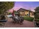 Outdoor dining area with a table and chairs, artificial turf, and view of the pool at dusk at 25821 N 41St Dr, Phoenix, AZ 85083
