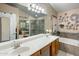 Bright bathroom boasting dual sinks, a spacious mirror, and a separate tub and shower at 25821 N 41St Dr, Phoenix, AZ 85083