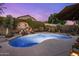 Beautiful pool area featuring a waterfall and rock feature, set against a backdrop of lush greenery at 25821 N 41St Dr, Phoenix, AZ 85083
