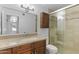 Well-lit bathroom with a sink and a glass-enclosed shower featuring neutral tile at 2619 S Los Altos --, Mesa, AZ 85202