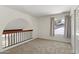 Bright bedroom features neutral carpet, white walls, railing, and a window overlooking the exterior at 2619 S Los Altos --, Mesa, AZ 85202