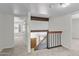 Bright hallway features neutral carpet, white walls, and wood railing overlooking front entrance at 2619 S Los Altos --, Mesa, AZ 85202