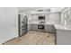 Bright modern kitchen featuring stainless steel appliances, gray cabinets, white backsplash, and wood-look flooring at 2619 S Los Altos --, Mesa, AZ 85202