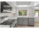 Bright modern kitchen featuring stainless steel appliances, gray cabinets, a tiled backsplash, and a breakfast bar at 2619 S Los Altos --, Mesa, AZ 85202