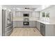 Modern kitchen featuring stainless steel appliances, gray cabinets, white backsplash, and wood-look flooring at 2619 S Los Altos --, Mesa, AZ 85202