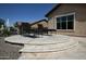 An outdoor patio area features nice hardscaping and comfy chairs at 27083 W Marco Polo Rd, Buckeye, AZ 85396