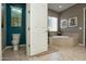 Bright bathroom featuring a toilet, soaking tub, and a neutral color scheme at 27083 W Marco Polo Rd, Buckeye, AZ 85396