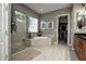 Elegant bathroom with a glass shower, soaking tub, and convenient access to a walk-in closet at 27083 W Marco Polo Rd, Buckeye, AZ 85396