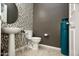Powder room featuring a modern vanity, mosaic tile accent wall, and decorative accessories at 27083 W Marco Polo Rd, Buckeye, AZ 85396