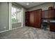 Comfortable carpeted bedroom featuring a Murphy bed and ample natural light from the window at 27083 W Marco Polo Rd, Buckeye, AZ 85396