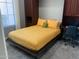 Cozy bedroom with built-in cabinets, a desk, and a comfortable bed with bright yellow comforter at 27083 W Marco Polo Rd, Buckeye, AZ 85396
