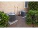 Two A/C units sit on concrete pads, surrounded by green shrubs and small gravel at 27083 W Marco Polo Rd, Buckeye, AZ 85396