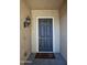 Covered front entry with a black door, elegant lighting, and textured walls at 27083 W Marco Polo Rd, Buckeye, AZ 85396