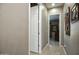 Hallway featuring tile flooring leading to carpeted bedroom, with decorative mirror hanging on the wall at 27083 W Marco Polo Rd, Buckeye, AZ 85396
