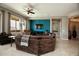 Spacious living room with a large sectional sofa and a modern ceiling fan at 27083 W Marco Polo Rd, Buckeye, AZ 85396