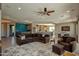 Open concept living area with a comfortable sectional, dining space, and plenty of natural light at 27083 W Marco Polo Rd, Buckeye, AZ 85396