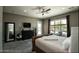 Well-lit main bedroom featuring a comfortable bed, dark furniture, and a serene view of the outdoors at 27083 W Marco Polo Rd, Buckeye, AZ 85396