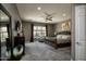 Spacious main bedroom featuring a large window, ceiling fan, and elegant furnishings at 27083 W Marco Polo Rd, Buckeye, AZ 85396