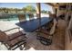 Spacious outdoor dining area with a large table, chairs, and a view of the pool and backyard at 27083 W Marco Polo Rd, Buckeye, AZ 85396