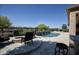 Stunning pool with a waterfall feature and a nearby firepit with seating on a paved patio at 27083 W Marco Polo Rd, Buckeye, AZ 85396