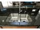 Close up of a double stainless steel sink with granite countertop and modern faucet at 27083 W Marco Polo Rd, Buckeye, AZ 85396