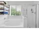 Bathroom featuring a soaking tub with a window, a separate glass shower, and industrial shelving at 2950 E Dublin St, Gilbert, AZ 85295
