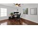 A bedroom with hardwood floors, fan, desk with monitors, and windows for natural light at 2950 E Dublin St, Gilbert, AZ 85295