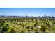 Expansive aerial view showcasing a lush golf course with a city skyline in the background at 3006 N Manor W Dr, Phoenix, AZ 85014