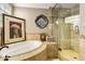 Luxurious bathroom featuring a soaking tub, glass shower, and decorative tile accents at 3006 N Manor W Dr, Phoenix, AZ 85014