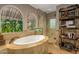 Bright bathroom featuring a soaking tub, walk-in shower, and exterior views at 3006 N Manor W Dr, Phoenix, AZ 85014