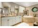 Elegant bathroom featuring double sinks, a soaking tub, and decorative artwork at 3006 N Manor W Dr, Phoenix, AZ 85014