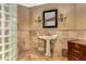 Elegant bathroom features a pedestal sink, decorative mirror, and glass block detail at 3006 N Manor W Dr, Phoenix, AZ 85014