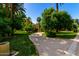 View of the home and circular driveway with lush, mature trees on a sunny day at 3006 N Manor W Dr, Phoenix, AZ 85014