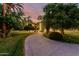 View of the home and circular driveway with lush, mature trees at sunset at 3006 N Manor W Dr, Phoenix, AZ 85014