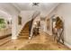 Grand foyer showcases a winding staircase, stone floors, arched entryways, and elegant décor at 3006 N Manor W Dr, Phoenix, AZ 85014