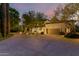 Elegant home exterior with driveway, lush trees, and soft landscape lighting enhancing the curb appeal at 3006 N Manor W Dr, Phoenix, AZ 85014