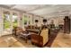 Inviting living room with warm tile floors, exposed beams, and multiple French doors to the outdoors at 3006 N Manor W Dr, Phoenix, AZ 85014