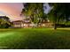 Expansive home exterior showcasing a lush lawn, covered patio, and mature trees, perfect for outdoor enjoyment at 3006 N Manor W Dr, Phoenix, AZ 85014