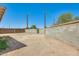 Spacious dirt backyard is surrounded by block fencing for privacy and includes a wooden gate at 3306 W Lupine Ave, Phoenix, AZ 85029