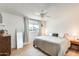 Cozy bedroom with light wood floors, ceiling fan, and view from the window at 3306 W Lupine Ave, Phoenix, AZ 85029