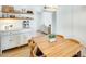 Bright dining area with wood table, chairs, and open shelving with white cabinets and modern appliances at 3306 W Lupine Ave, Phoenix, AZ 85029