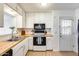Bright kitchen with white cabinets, butcher block countertops and stainless-steel sink with a door to the backyard at 3306 W Lupine Ave, Phoenix, AZ 85029