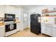 Well-lit kitchen features white cabinets, open shelves, and a contrasting black refrigerator at 3306 W Lupine Ave, Phoenix, AZ 85029