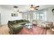 Cozy living room with a plush green sofa, ceiling fans, and a glass-topped coffee table at 3306 W Lupine Ave, Phoenix, AZ 85029