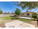 Backyard with a covered patio, large lawn, and mature trees at 3732 E Greenway Ln, Phoenix, AZ 85032