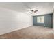 Spacious bedroom with a ceiling fan and window offering natural light and a blue accent wall at 3732 E Greenway Ln, Phoenix, AZ 85032